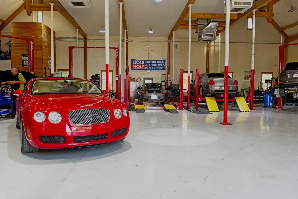 European car maintenance in Jacksonville, FL by Mack Motorwerks. Image of a red convertible being serviced inside a luxury auto repair shop